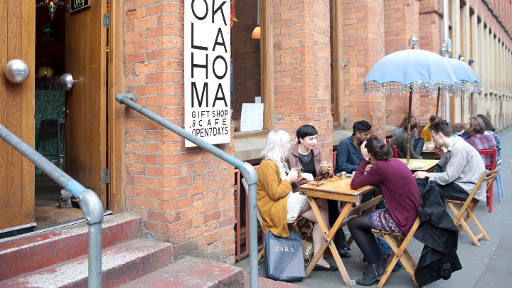 Group of people eating outside at tables 