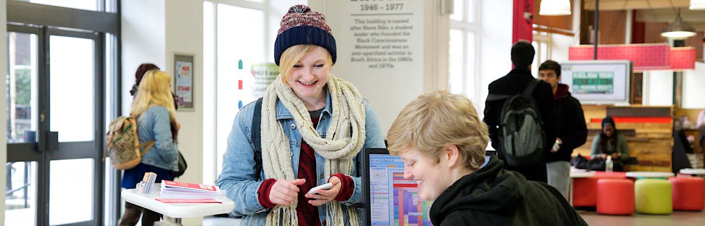 Student talking to a member of staff on front desk