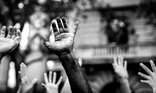 Multicultural hands raised in the air asking for freedom