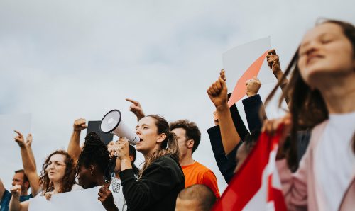 People at a protest with boards and a megaphone