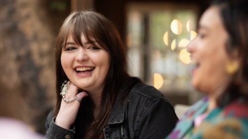 Student facing camera and laughing with another 