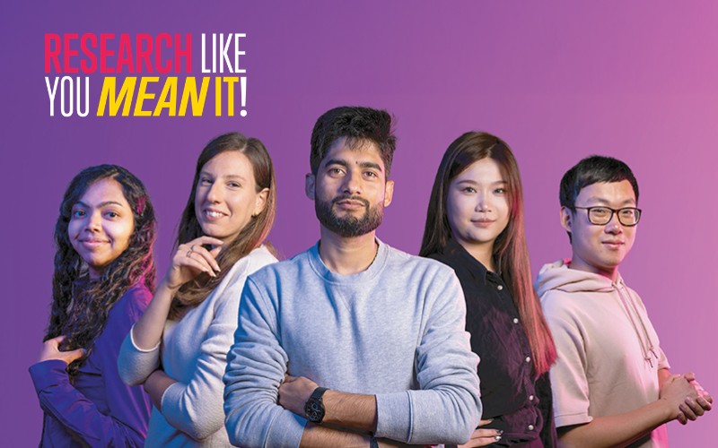 Five students stood facing the camera. Text reads 'Research Like You Mean It'