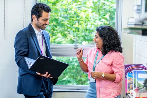 Student and supervisor stood in conversation with laptop