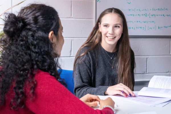 PhD student and academic smiling in conversation