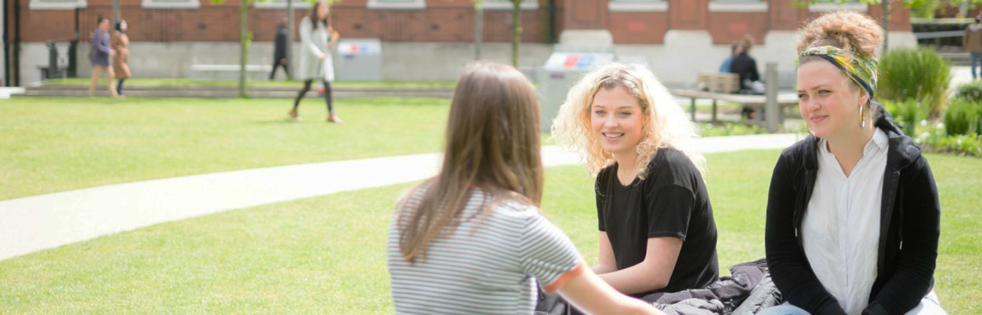 Students sat on grass outside the Samuel Alexander Building