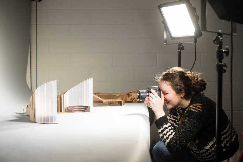 Student photographing architecture model. 
