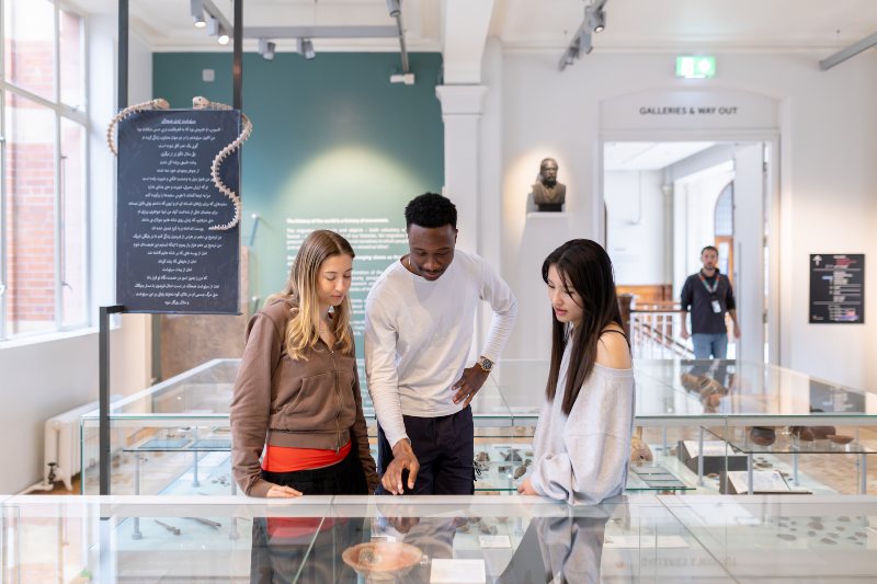 Students discussing exhibits in Manchester Museum. 