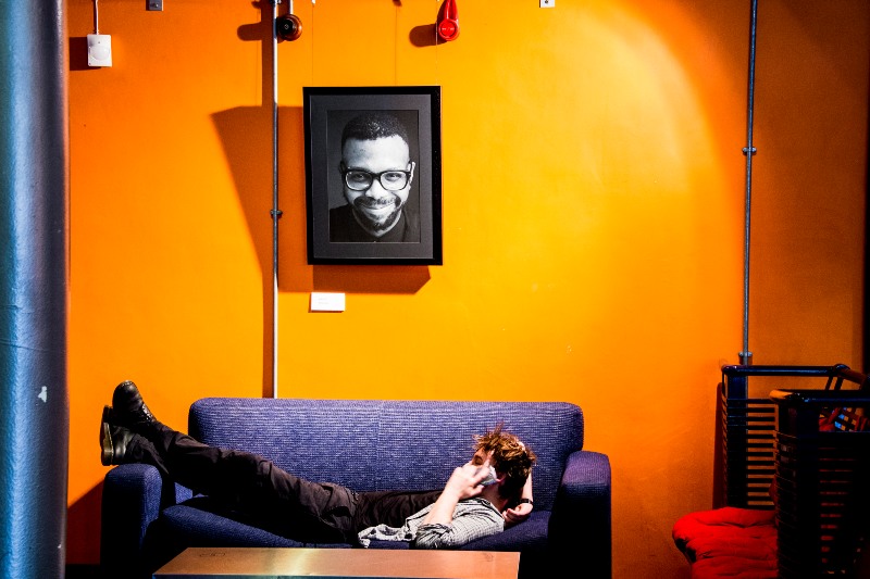 A student on a sofa in the theatre. 