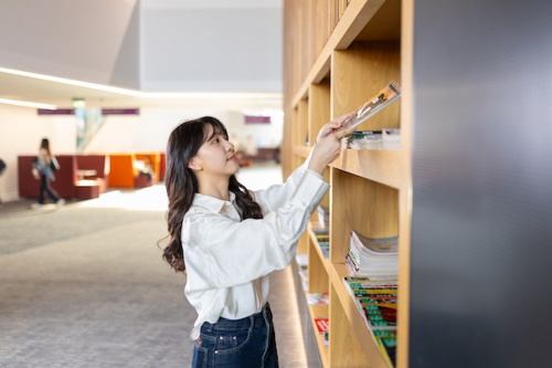 Student putting books on a bookshelf