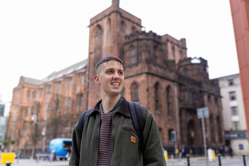Student standing outside the John Rylands Library.