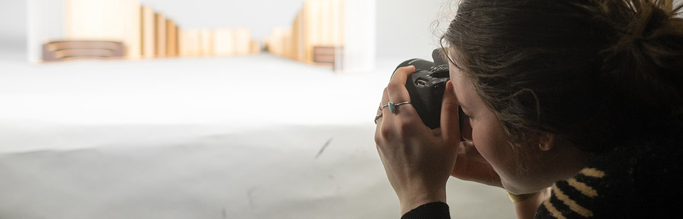 Female student taking photo of architectural model