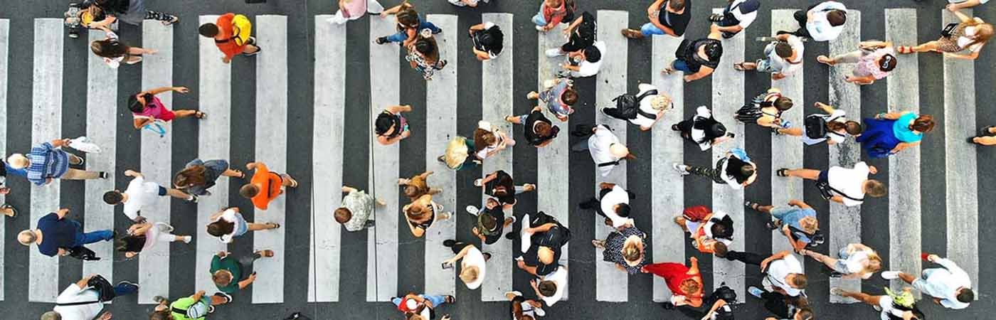 Bird's eye view of dozens of pedestrians crossing a zebra crossing