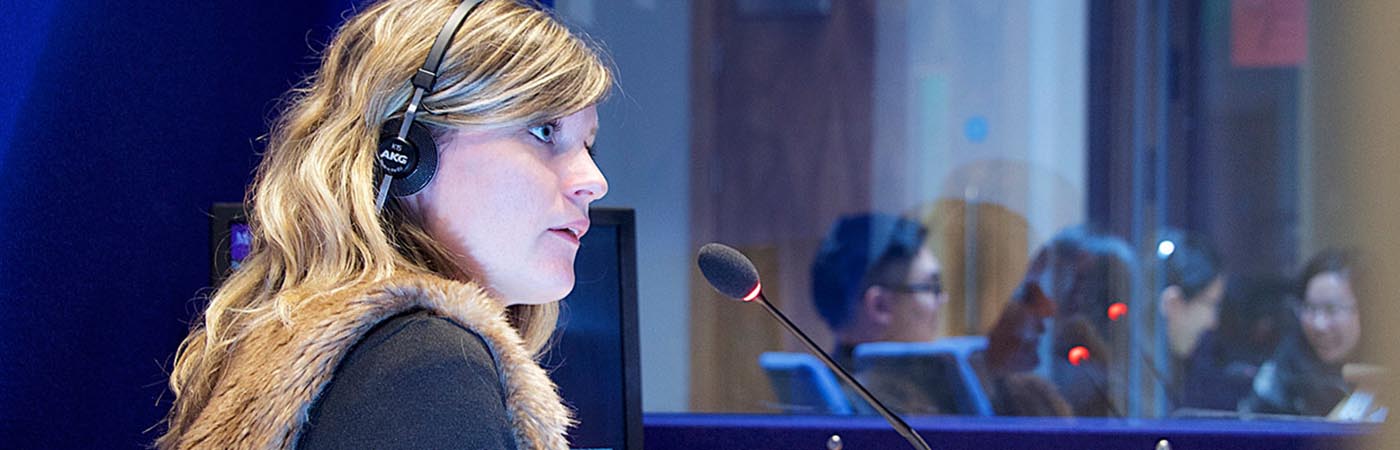 Female looking sideways at a desk with a microphone